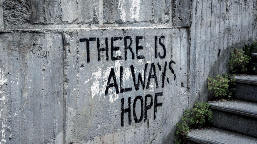 Graffiti on concrete wall reads 'There is always hope' next to outdoor stairs.
